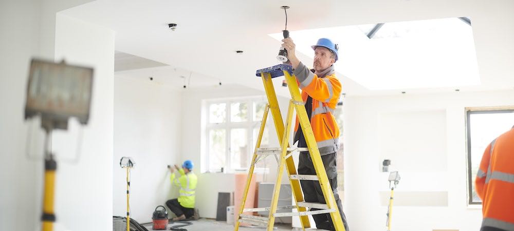 A photo of Attaboy Electrician Ken Caryl working on a light fixture.